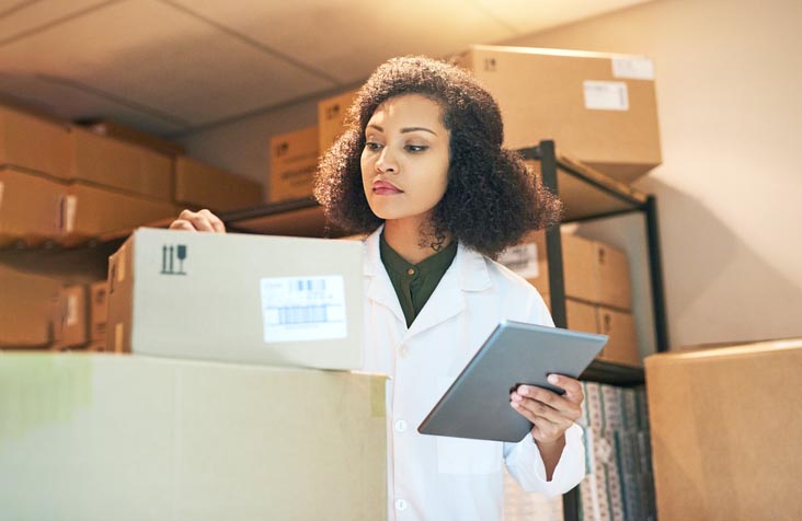 Shot of a young woman using a digital tablet while doing inventory in the storeroom of a pharmacy